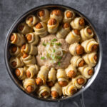 Vegan pigs in a blanket served in a round skillet.