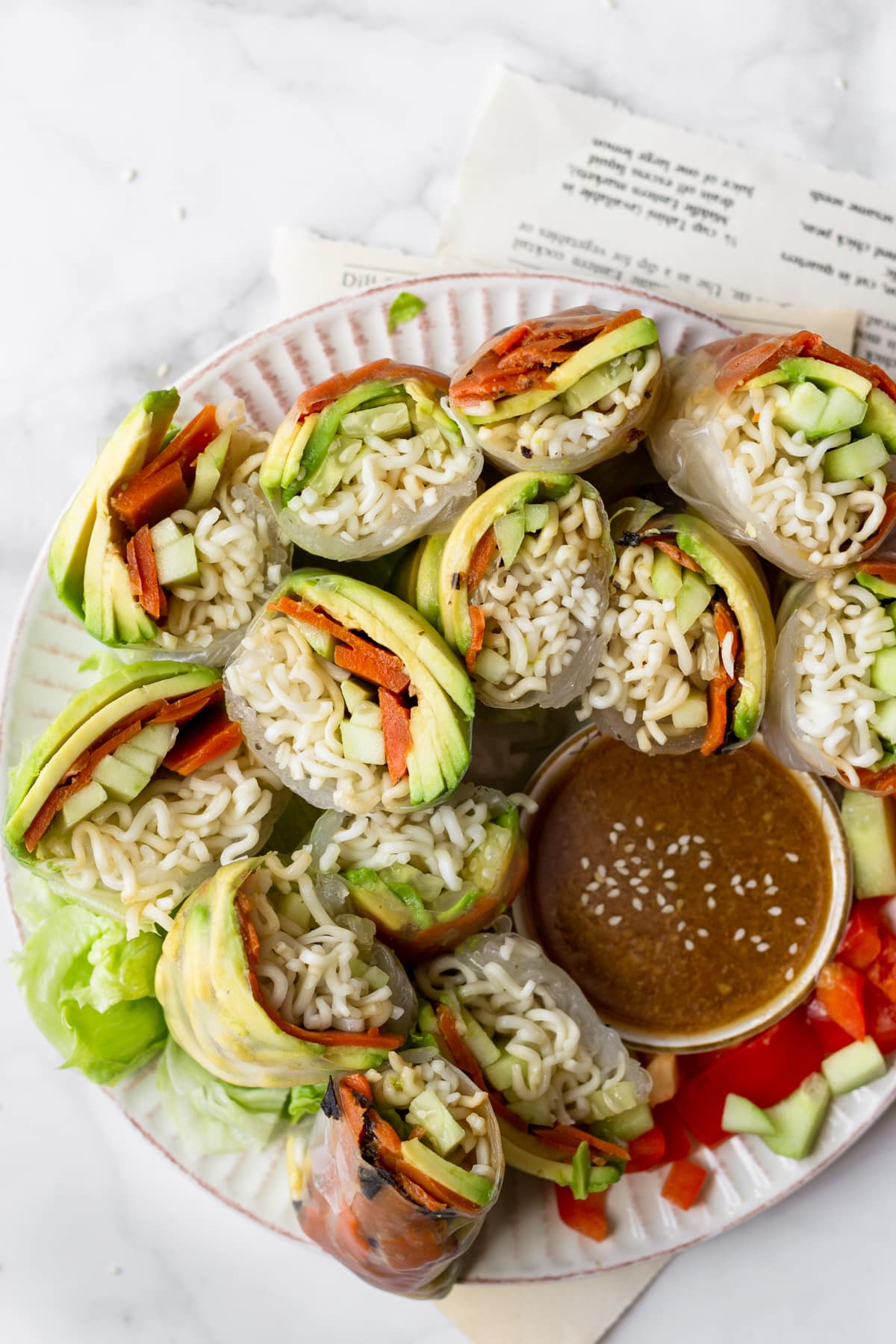 avocado summer rolls cut in half served on a plate with sesame vinaigrette