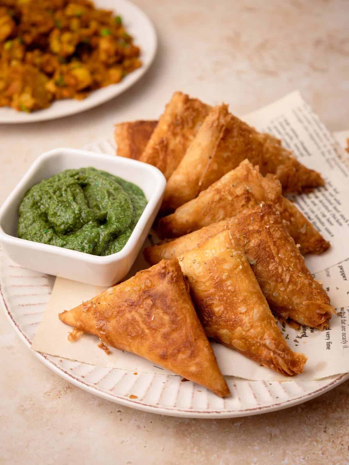 Cocktail Samosa assembled on a plate with coriander chutney.