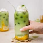 iced mango matcha latte topped with whipped coconut cream